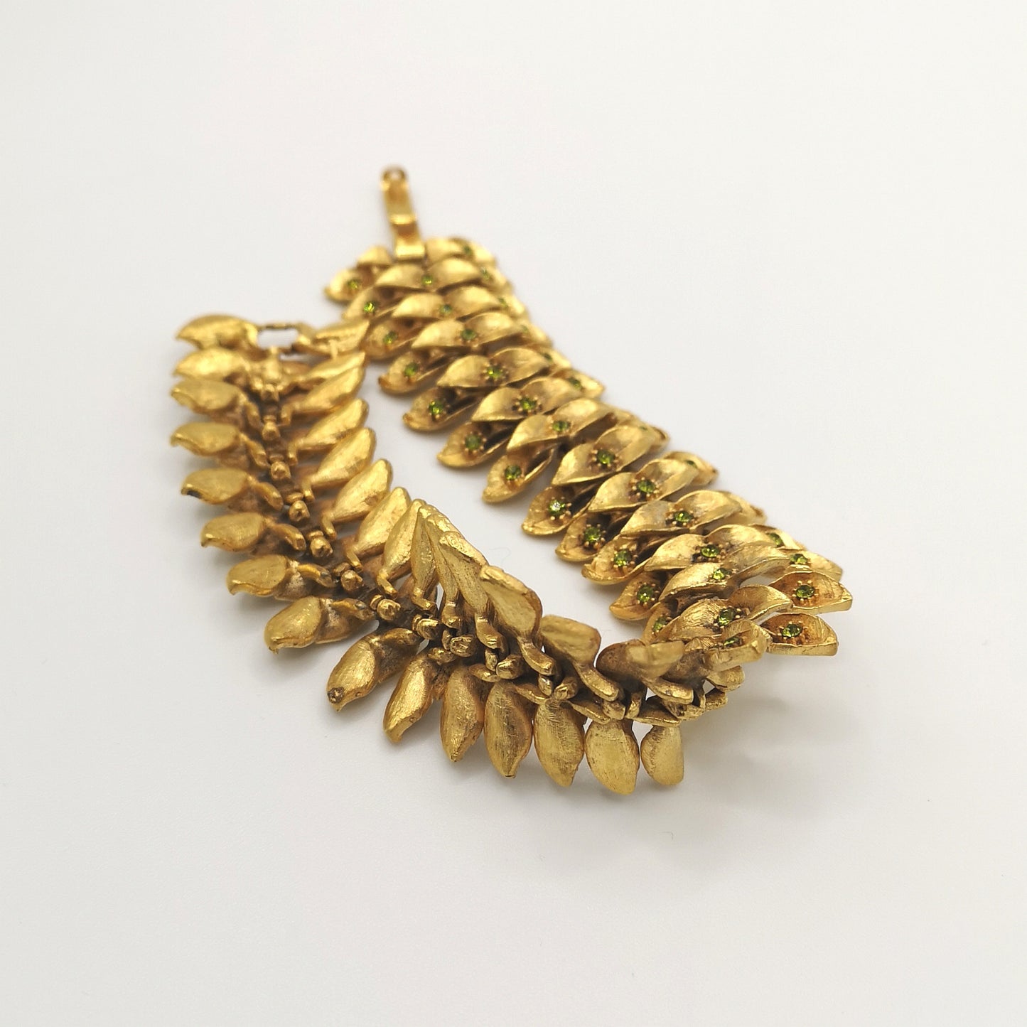 1960s vintage articulated bracelet with leaf motif, gold-plated with green rhinestones - back view of the jewel